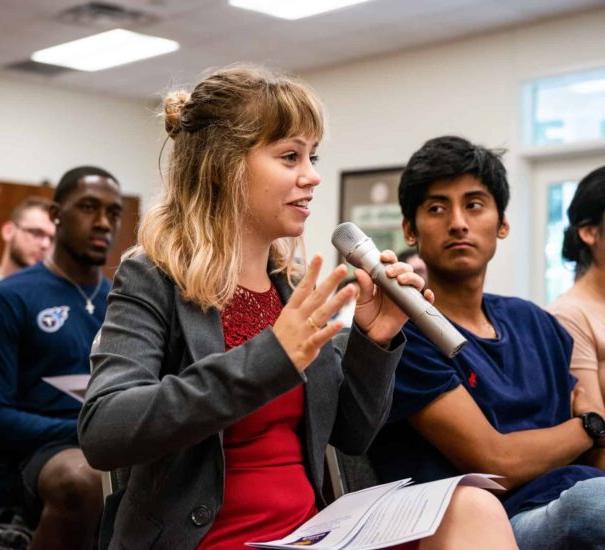 Student speaking holding a speaker.