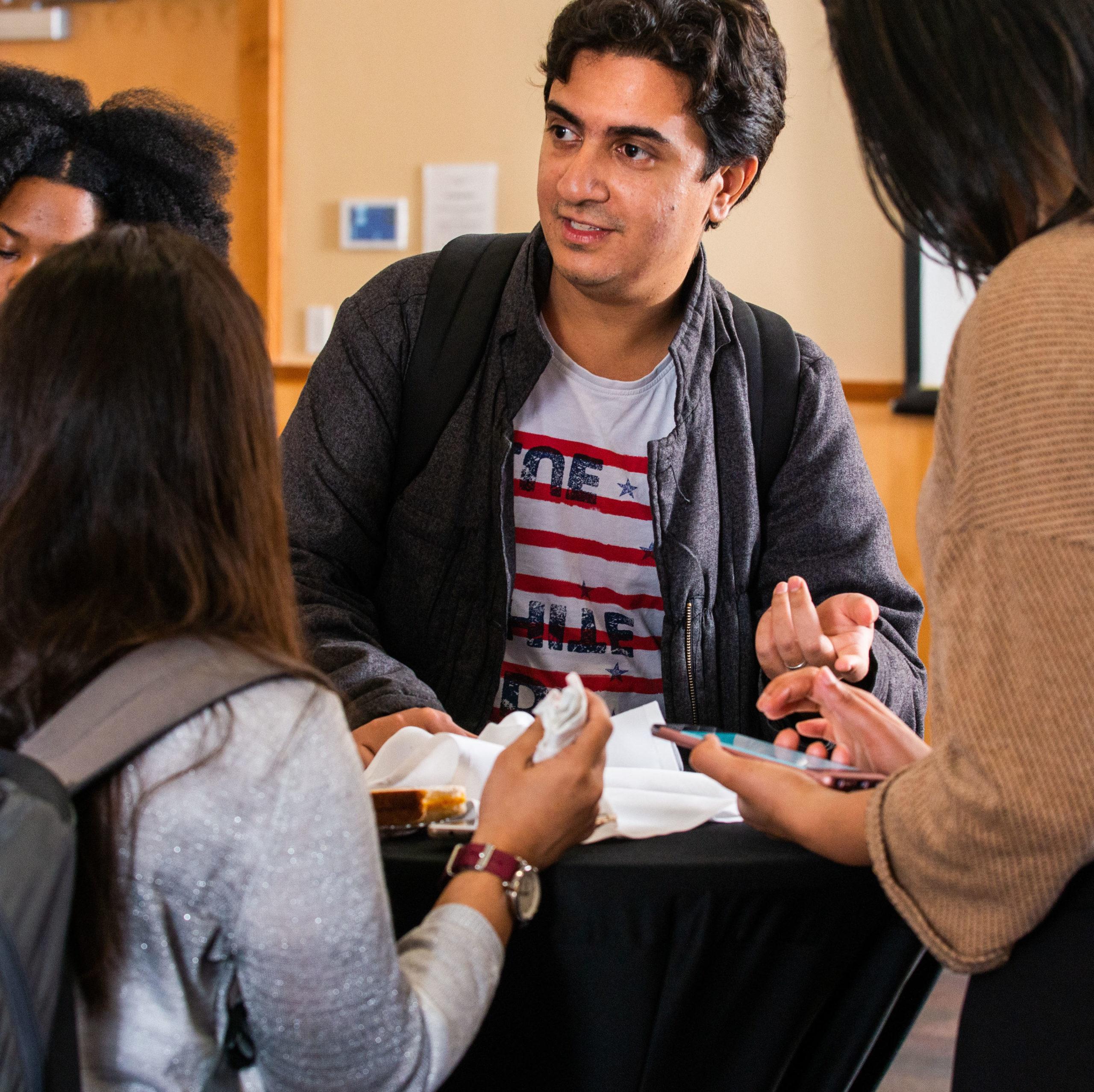 Students having a conversation around a table.