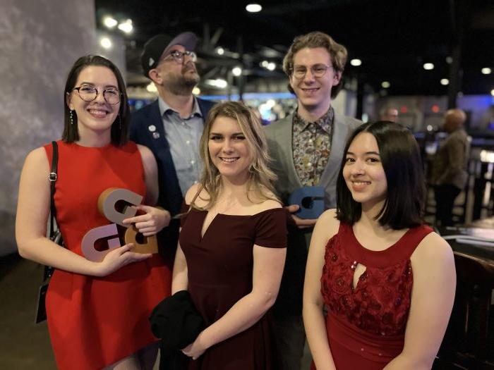 A group of five people pose for a photo.