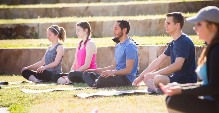 学生 meditate on the outdoor amphitheater lawn at A&M-商务