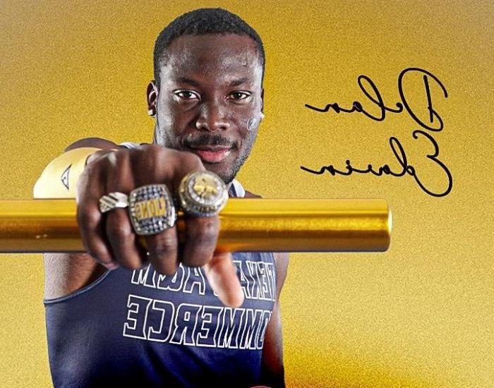 Athlete holds arm out in front of him to show hand with three school rings on his fingers.