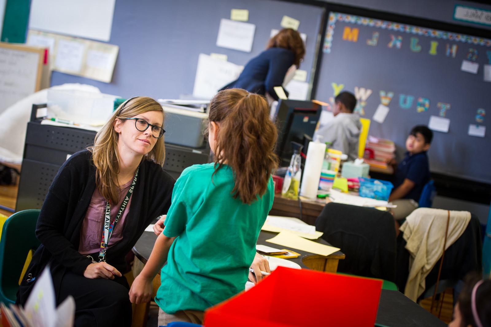 A student teacher speaking with a child.