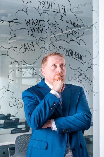 A person standing in front of a dry erase board with various notes written on it.